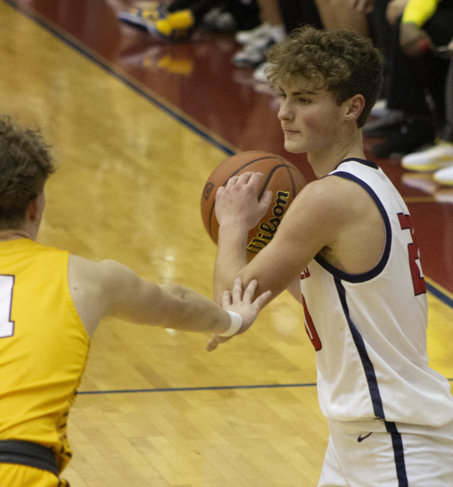 Junior Eli Ellis looks for an open player to pass to as he keeps away from the Mooresville defense at the Homecoming game on Friday, January 20.   Photo by Aidan Menke