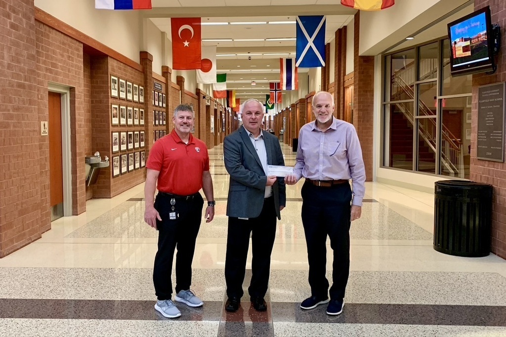 PHS Principal Pat Cooney (left) and Superintendent Scott Olinger (right) accept a scholarship check from Heritage Trail Correctional Facility Warden Donnie Emerson.