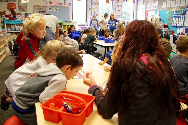 Kindergarten students were asked to estimate how many water drops could 'sit' on top of a penny. Then, with a parent carefully adding the droplets, they counted to test their hypotheses. 