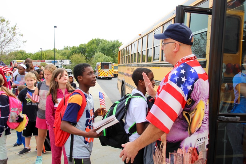 At dismissal, students from each class lined the front sidewalk with flags, while everyone left in silence.