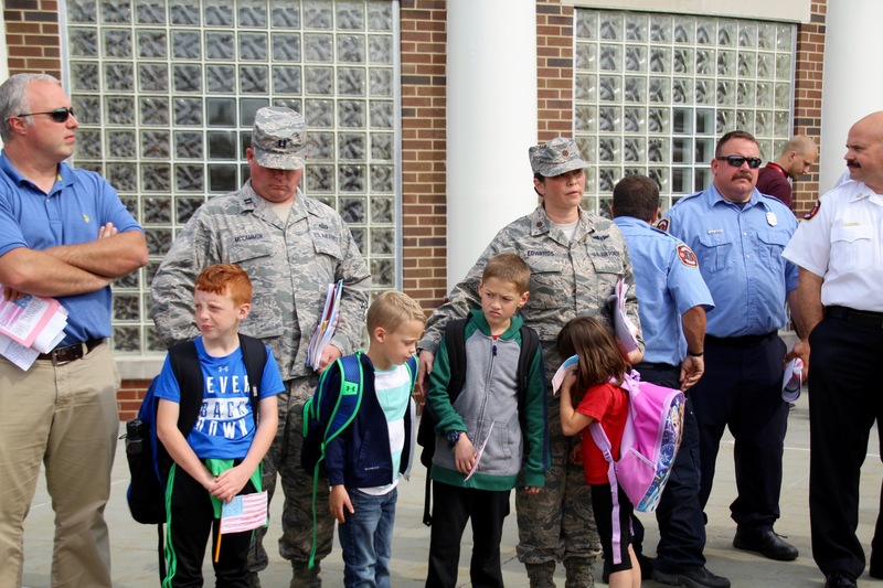 At dismissal, students from each class lined the front sidewalk with flags, while everyone left in silence.