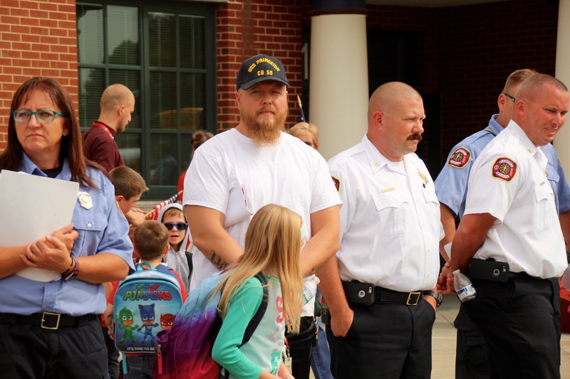 At dismissal, students from each class lined the front sidewalk with flags, while everyone left in silence.