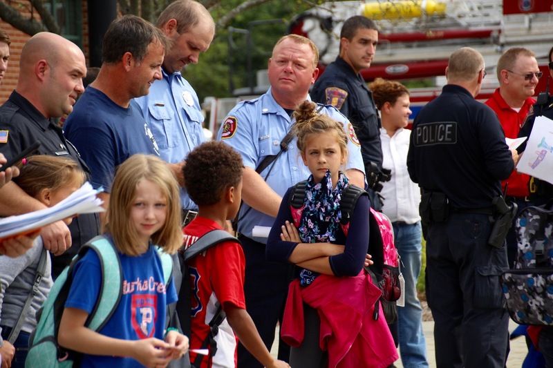 At dismissal, students from each class lined the front sidewalk with flags, while everyone left in silence.