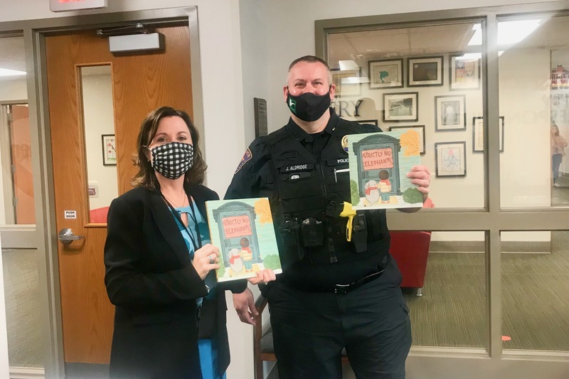 Central Elementary Principal, Julie Thacker, with Deputy Chief Joe Aldridge, accepting copies of the Men IN Action READ book for 2021