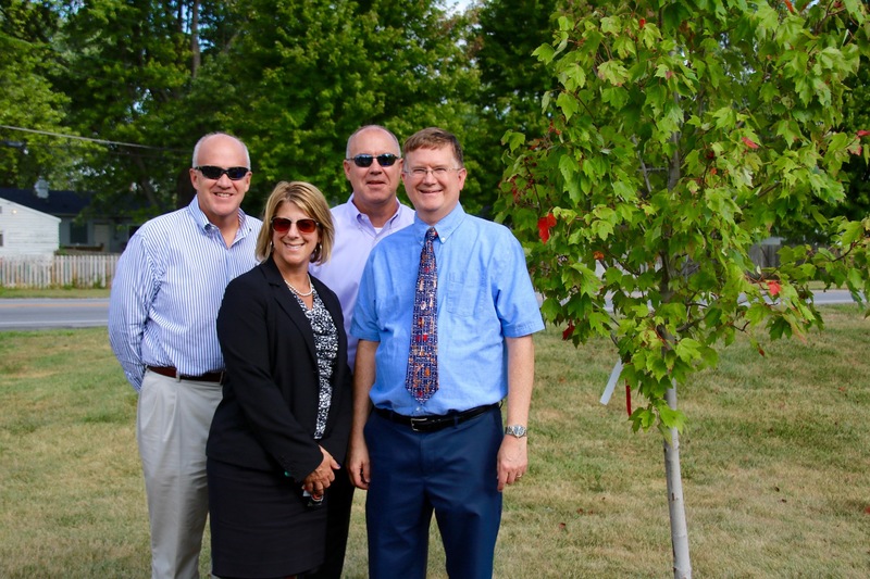 Scott Olinger, Laura DelVecchio and Jud Wolfe pose with Brad DeHoff at his tree planting ceremony. 