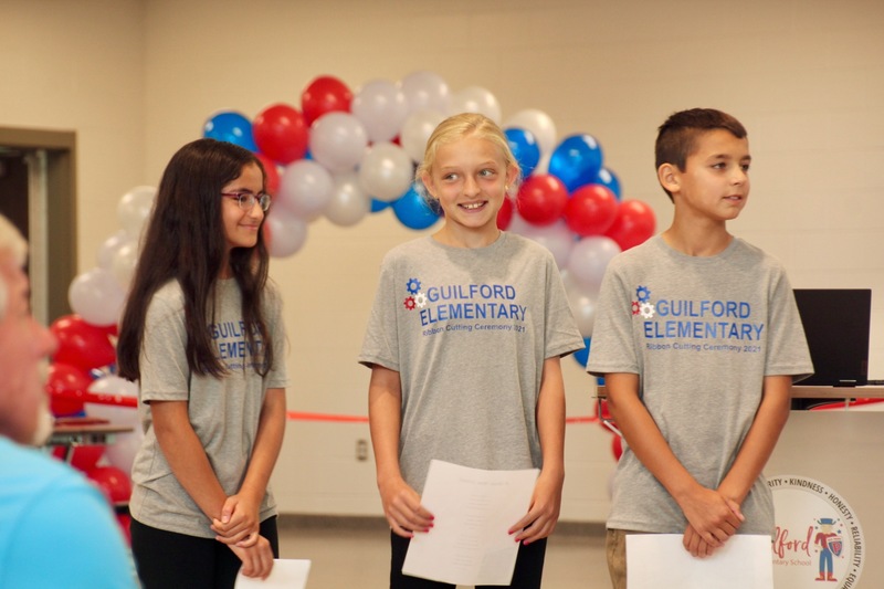 Student ambassadors wait their turn to share the poems they wrote in honor of the school's opening.