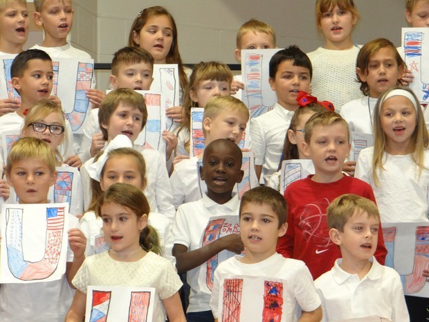 Holding their patriotic artwork and beaming from ear to ear, these students sang their hearts out for their guests.