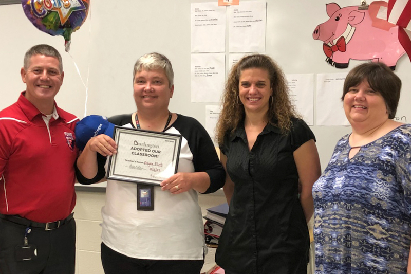 PCMS Special Education teacher, Myra Flint, is shown here receiving an award and cash donation from Plainfield's Burlington Coat Factory managers.