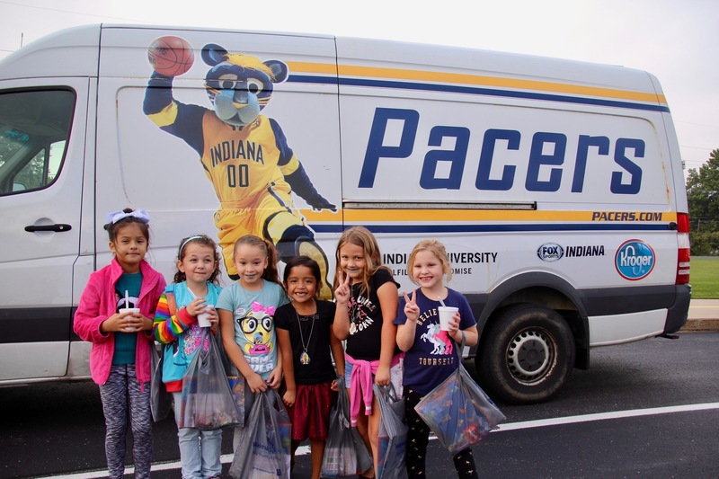 Students pose in front of the Pacers/Boomer van