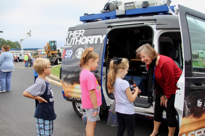 Students hold the mic at the FOX59 news van