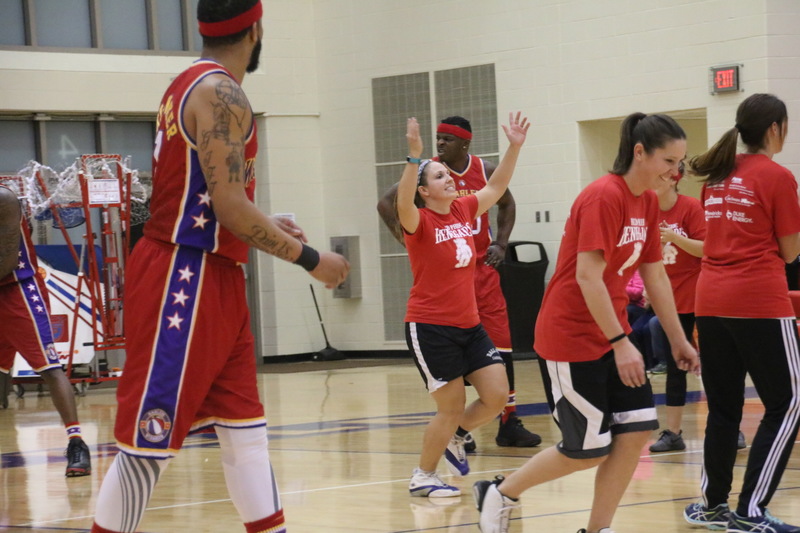 Mrs. Riester throws her hands up to celebrate a basket